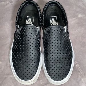Black Vans slip on sneakers.
